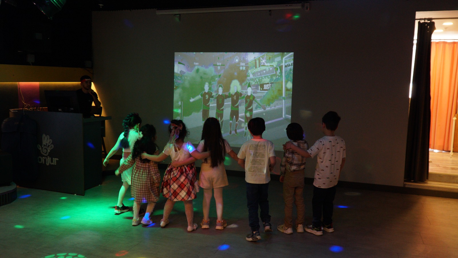 Children playing a dance game on the big screen in Bonjur's mini disco hall, Ümraniye
